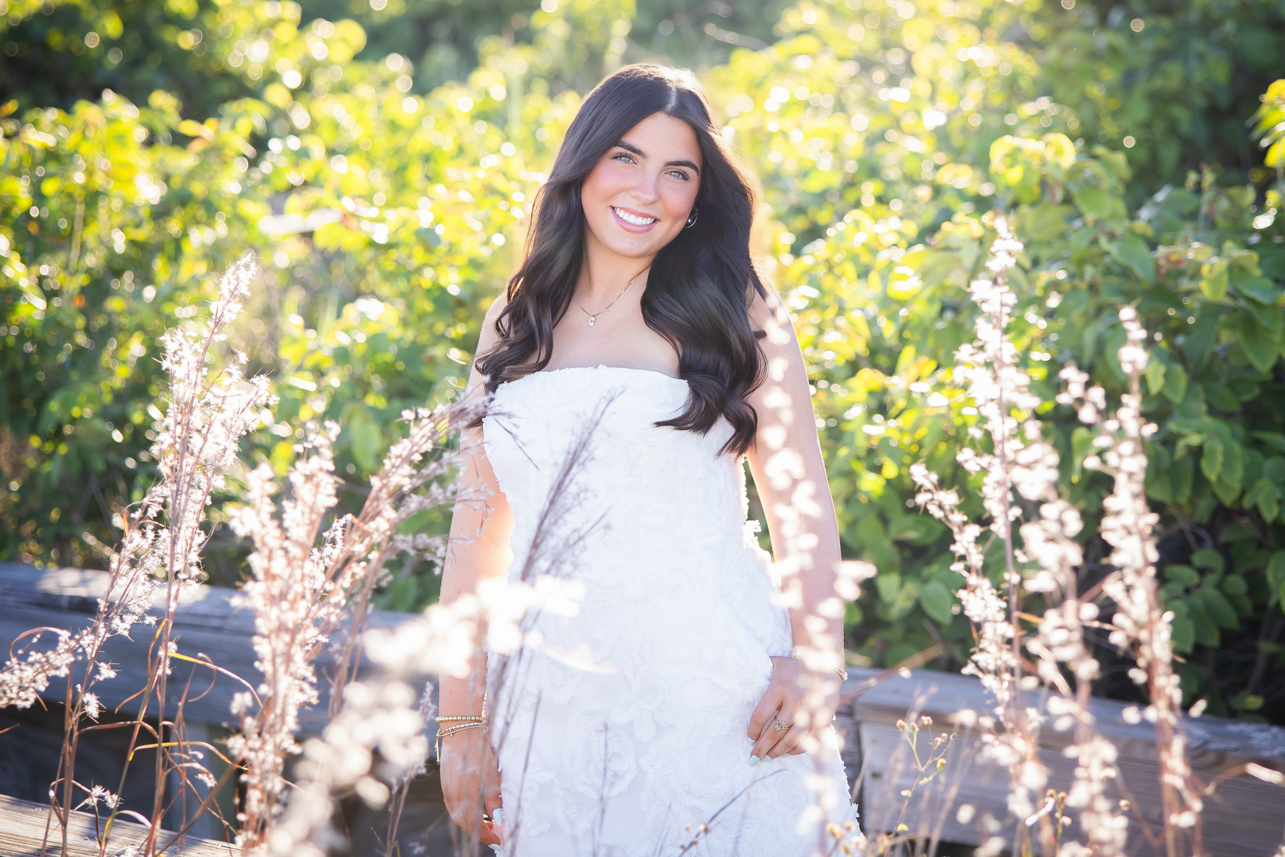 Senior girl standing among the sea oats at Jetty Park during a beach senior photo session in Cape Canaveral, Florida.