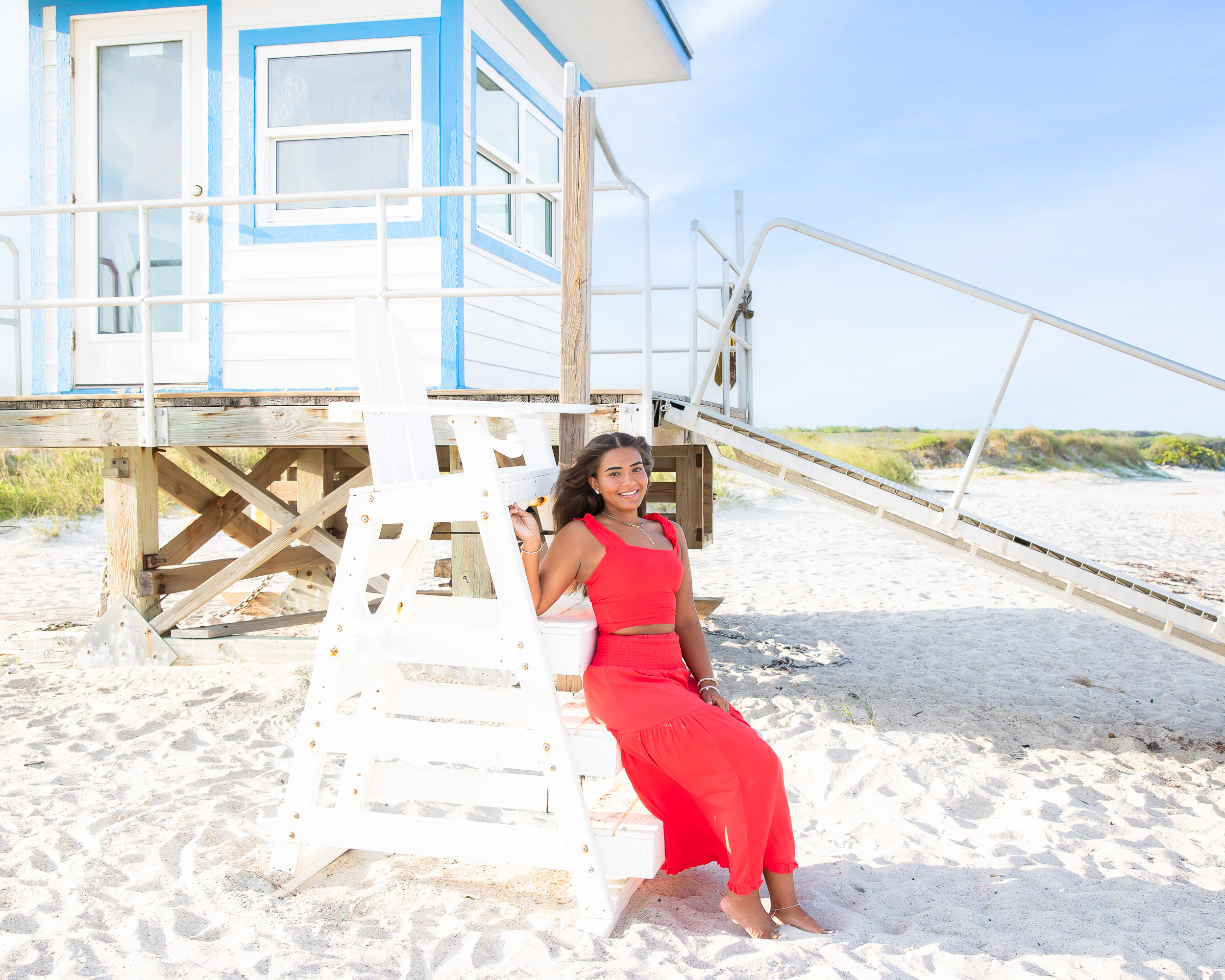 Senior portrait at the colorful lifeguard stand at Jetty Park in Cape Canaveral, Florida. A fun beach backdrop for senior pictures by Shea Rose Photography.