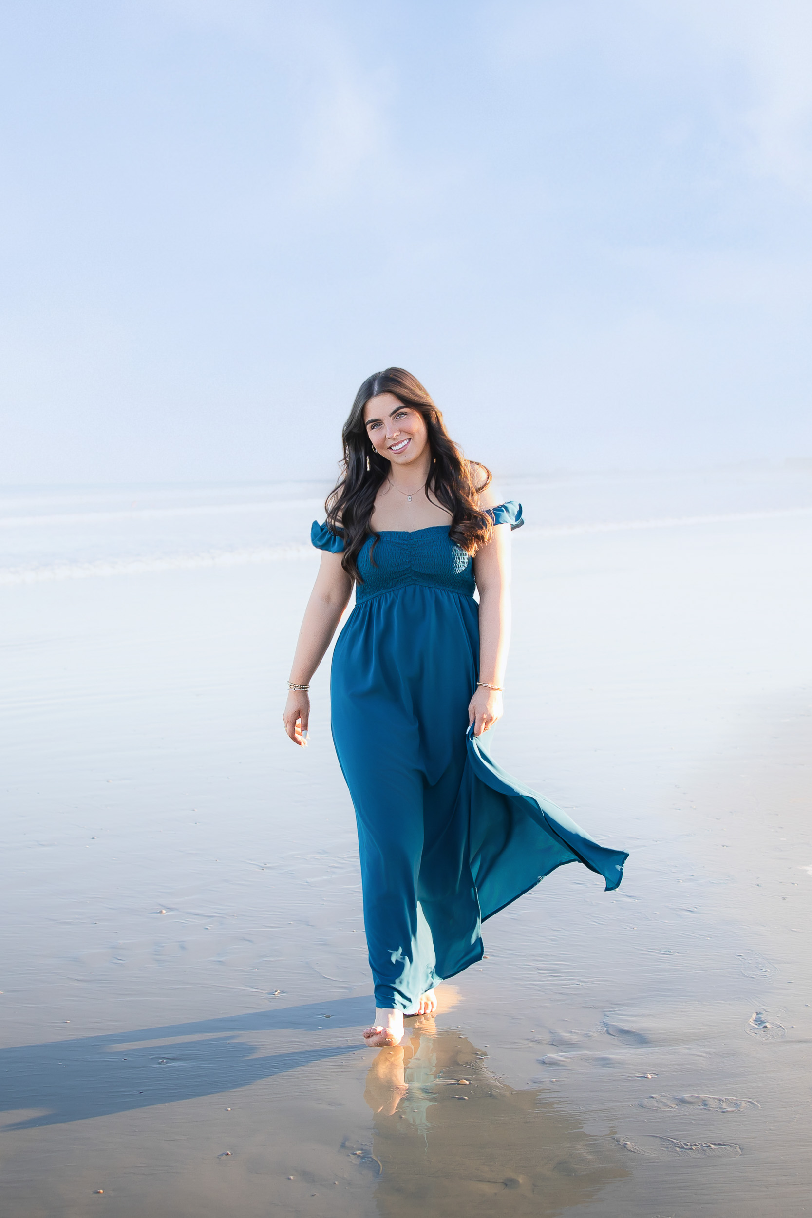 Senior pictures at Jetty Park in Florida featuring a blue dress on the beach